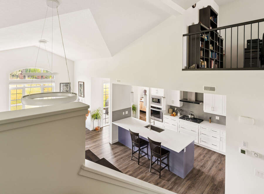 Experience modern living in this stunning open-concept home featuring a spacious kitchen with a large island and sleek white cabinetry.