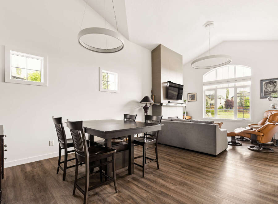 Experience modern living in this spacious open-concept home, featuring a vaulted ceiling with contemporary pendant lighting.