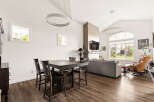 Experience modern living in this spacious open-concept home, featuring a vaulted ceiling with contemporary pendant lighting.