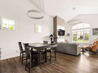 Experience modern living in this spacious open-concept home, featuring a vaulted ceiling with contemporary pendant lighting.