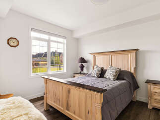 This charming bedroom features a spacious wooden bed with a decorative headboard, complemented by a matching nightstand and dresser.