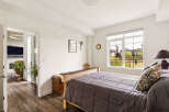 This inviting bedroom features a comfortable bed with a plush comforter and decorative pillows, perfect for relaxation.