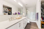 This modern bathroom features a spacious double vanity with sleek silver fixtures and ample counter space.