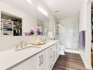 This modern bathroom features a spacious double vanity with sleek silver fixtures and ample counter space.