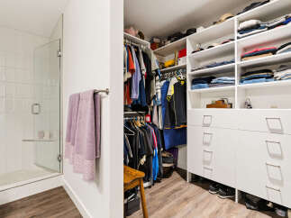 Step into this spacious walk-in closet, featuring ample shelving and drawers for organized storage.