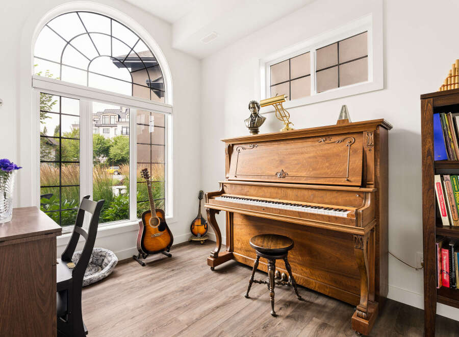 Experience the joy of music in this beautifully appointed room, featuring a classic upright piano and a collection of guitars.