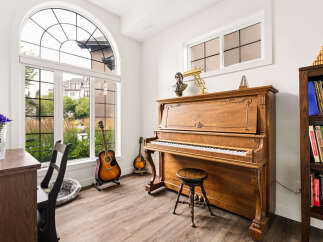 Experience the joy of music in this beautifully appointed room, featuring a classic upright piano and a collection of guitars.