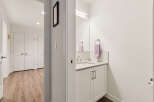 Step into a bright and modern hallway featuring a sleek vanity with a silver faucet and a plush purple towel.