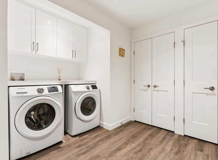 This laundry room features a stacked Samsung washer and dryer set, offering ample space for your laundry needs.