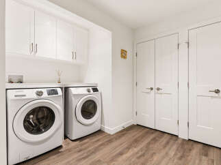 This laundry room features a stacked Samsung washer and dryer set, offering ample space for your laundry needs.