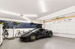 This spacious garage features a sleek dark sports car and two bicycles, perfect for the automotive enthusiast or cycling aficionado.