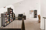 This spacious loft area features a dedicated home office with ample built-in bookshelves and a comfortable desk setup.