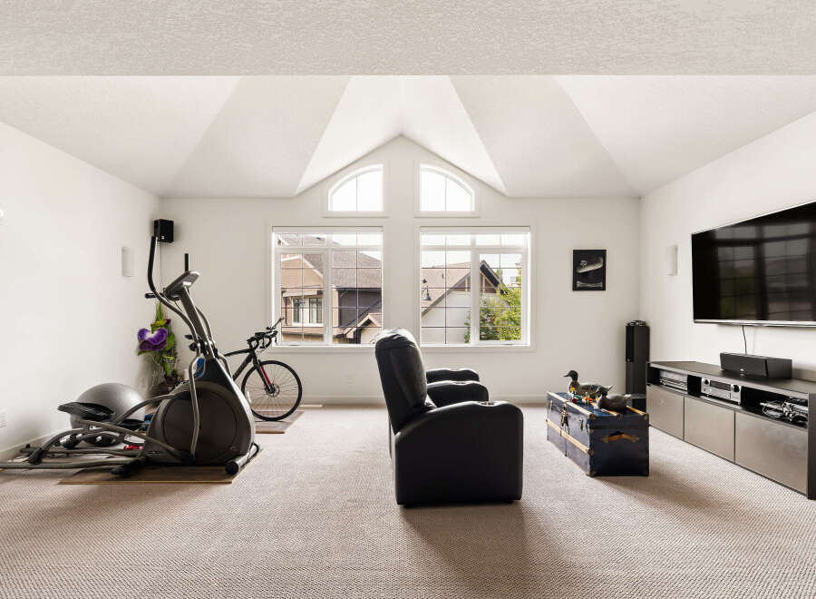 This spacious room offers a versatile layout, perfect for both fitness and entertainment.