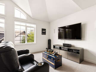 Experience ultimate relaxation in this home theater room, featuring plush black leather recliners with built-in cup holders.