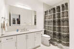 This modern bathroom features a sleek vanity with ample storage and a clean white countertop.