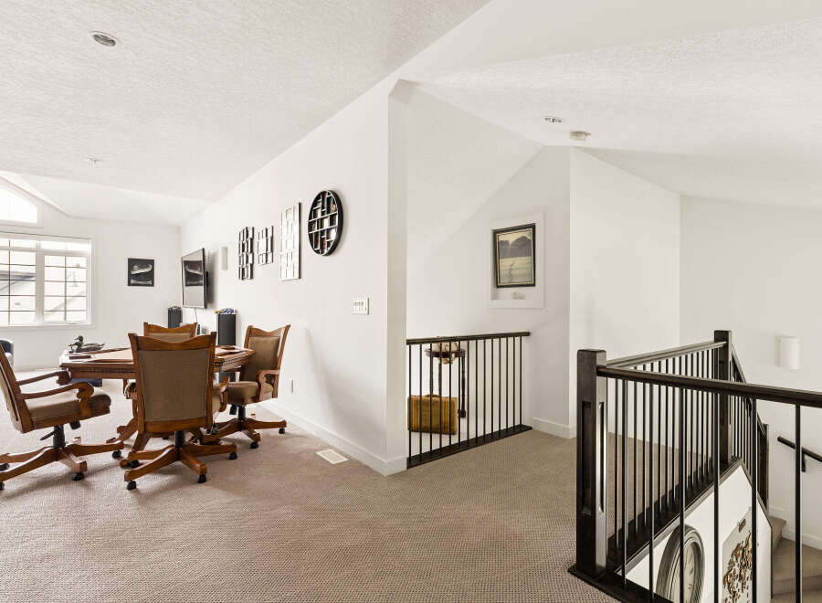 This spacious loft area features a comfortable seating arrangement around a game table, perfect for entertaining guests or enjoying a quiet evening.