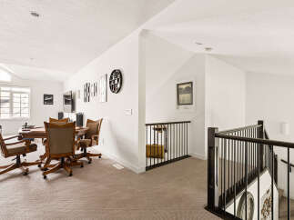 This spacious loft area features a comfortable seating arrangement around a game table, perfect for entertaining guests or enjoying a quiet evening.