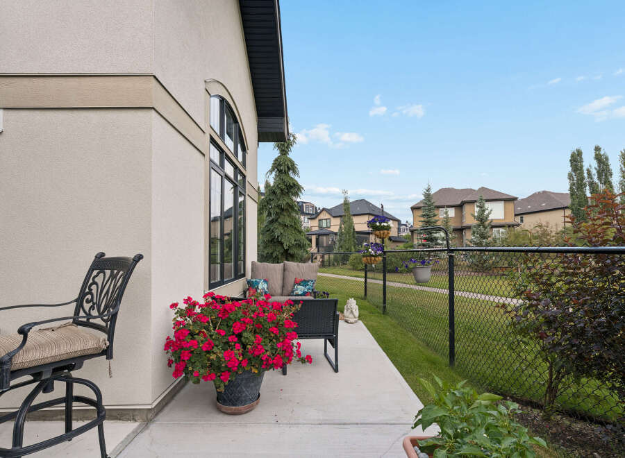 Enjoy outdoor living on this charming patio, complete with comfortable seating and vibrant floral arrangements.