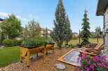 Enjoy outdoor living in this beautifully landscaped backyard, featuring a raised garden bed perfect for growing your own vegetables.