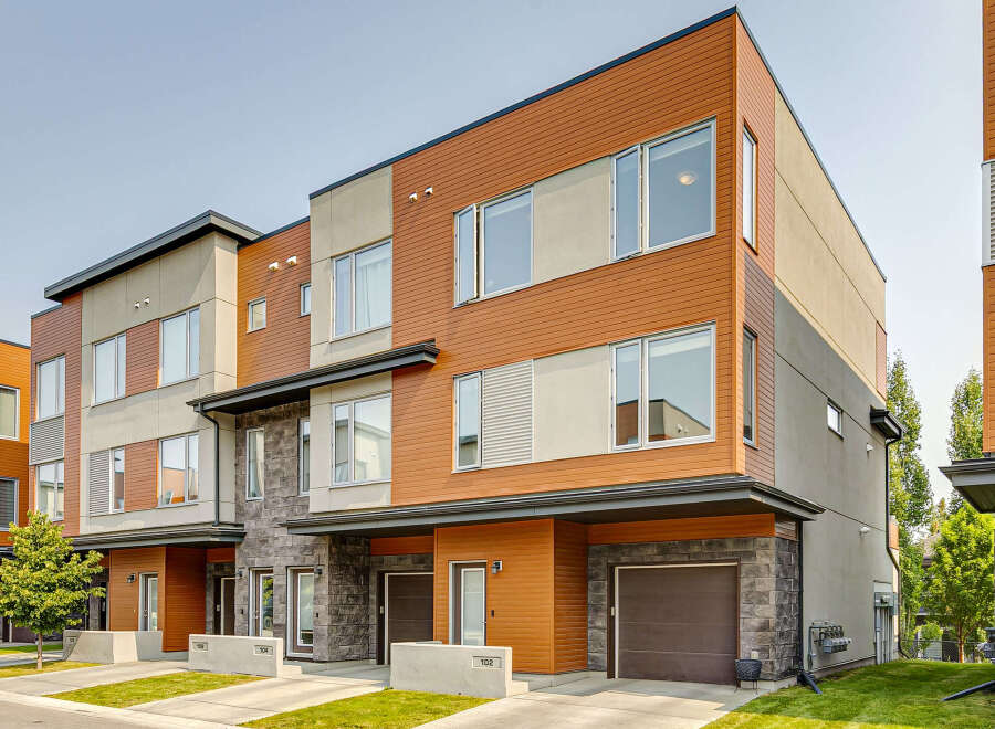 Discover modern living in these stunning townhomes featuring a striking combination of warm wood siding and sleek stone accents.