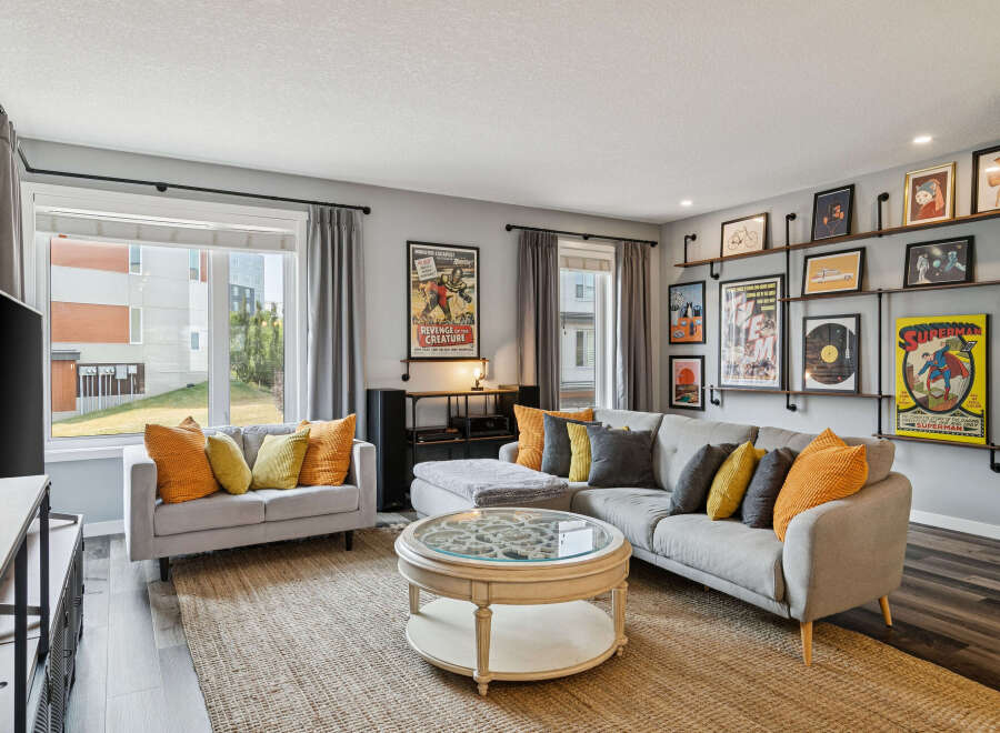 Step into this inviting living room, featuring a spacious sectional sofa adorned with vibrant accent pillows, perfect for cozy gatherings.