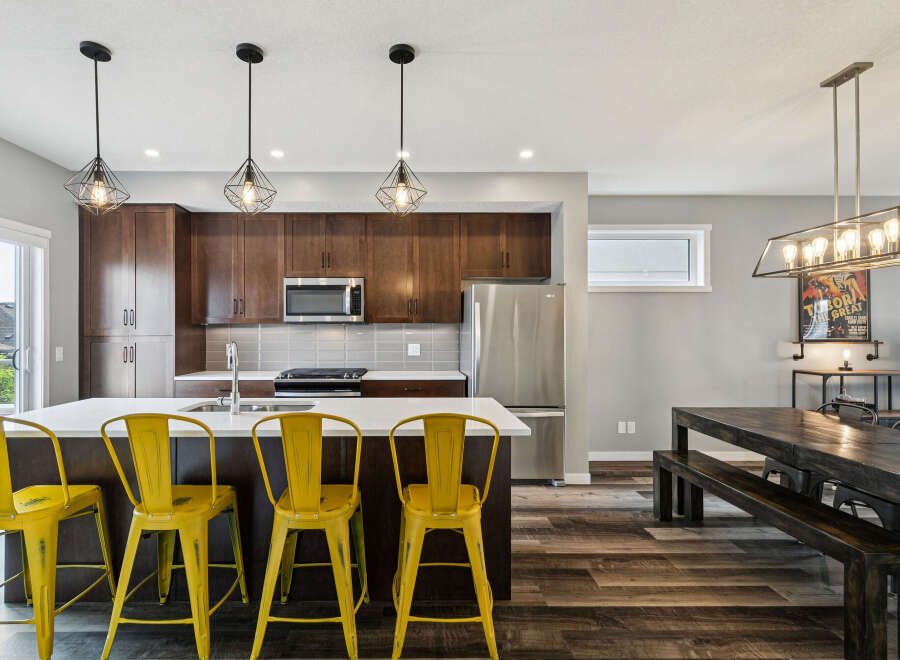 Experience modern living in this stunning kitchen featuring rich espresso cabinetry and a sleek white quartz island, perfect for casual dining or entertaining.