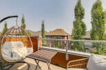 Enjoy your morning coffee or evening relaxation on this charming balcony, complete with a comfortable hanging chair and a small table.