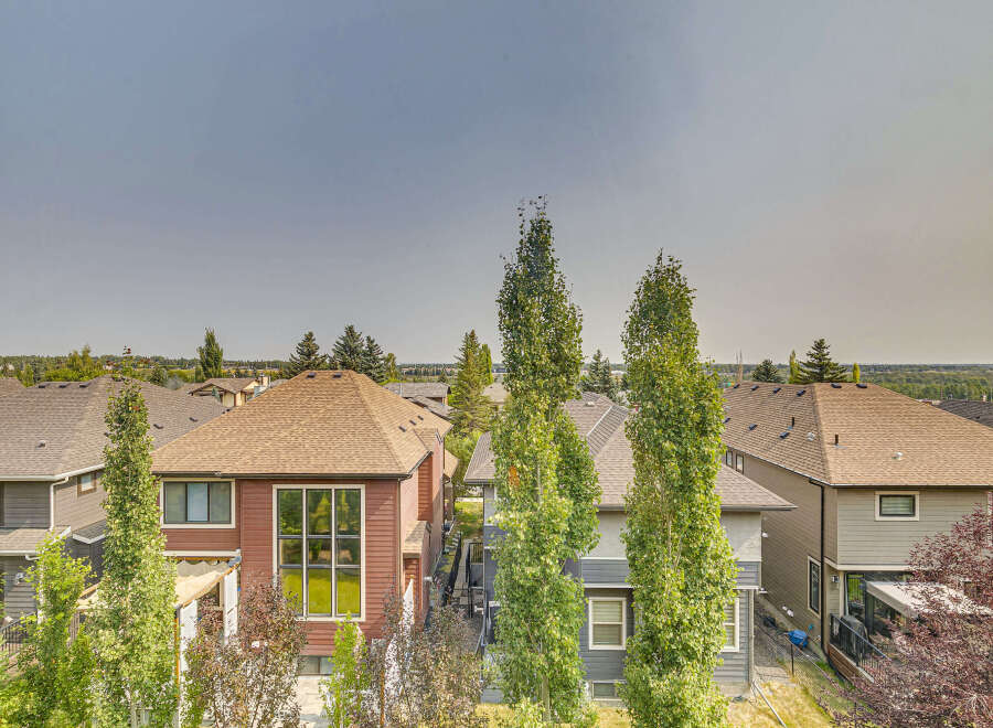 Discover this stunning property featuring a modern exterior with rich wood and grey siding, complemented by a durable asphalt shingle roof.