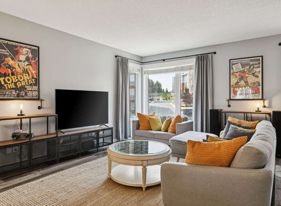 Step into this inviting living room, featuring a large flat-screen TV and stylish industrial-inspired media console.