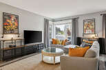 Step into this inviting living room, featuring a large flat-screen TV and stylish industrial-inspired media console.
