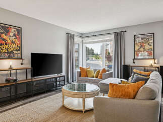Step into this inviting living room, featuring a large flat-screen TV and stylish industrial-inspired media console.