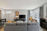 Step into this inviting living room, featuring a spacious sectional sofa perfect for gatherings and a large television for entertainment.