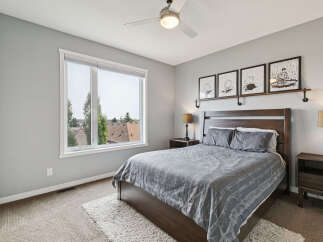 This inviting bedroom features a comfortable queen-sized bed with a stylish grey patterned comforter, complemented by two matching pillows.