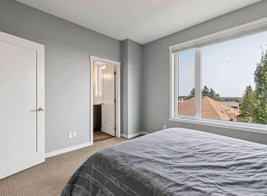 Experience comfort and style in this inviting bedroom, featuring a plush grey comforter on a spacious bed.