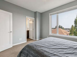 Experience comfort and style in this inviting bedroom, featuring a plush grey comforter on a spacious bed.