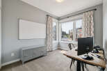 This home office features a large whiteboard for brainstorming and a grey locker-style cabinet for storage.