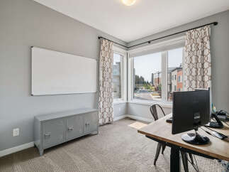 This home office features a large whiteboard for brainstorming and a grey locker-style cabinet for storage.
