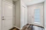 Step into this inviting entryway featuring a sleek white door with a modern brushed nickel handle, perfect for welcoming guests.