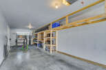 Maximize your storage and organization in this spacious garage featuring custom-built wooden shelving units.