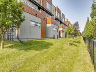 Discover modern living in this stunning townhouse complex, featuring a sleek design with warm wood accents and expansive windows.