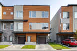 Discover modern living in this stunning townhouse featuring a striking facade with warm wood accents and sleek stone detailing.