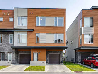 Discover modern living in this stunning townhouse featuring a striking facade with warm wood accents and sleek stone detailing.