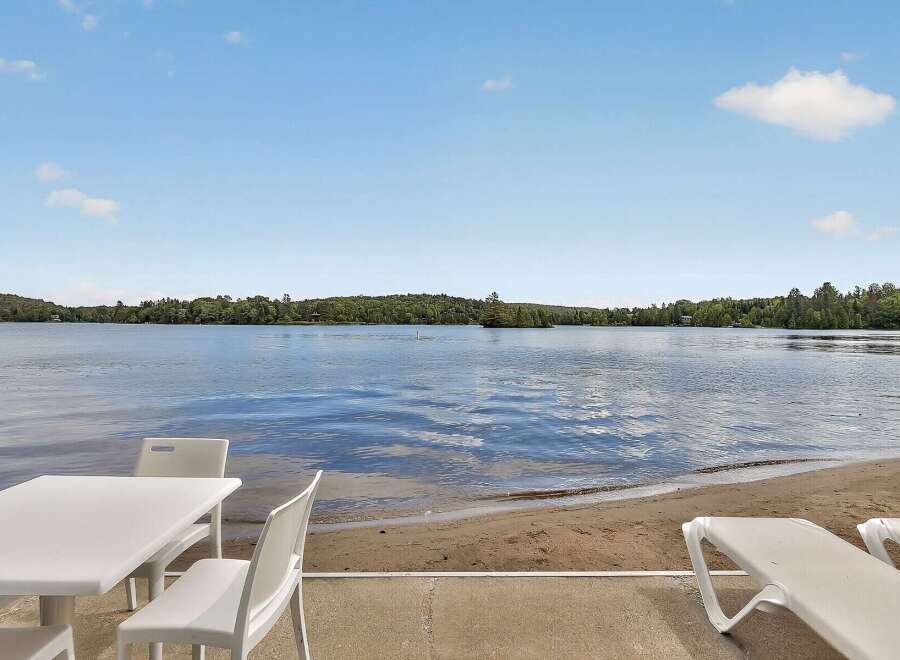 Enjoy serene lakefront living with this stunning property, featuring a private sandy beach perfect for relaxation and recreation.