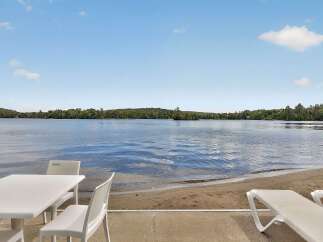 Enjoy serene lakefront living with this stunning property, featuring a private sandy beach perfect for relaxation and recreation.