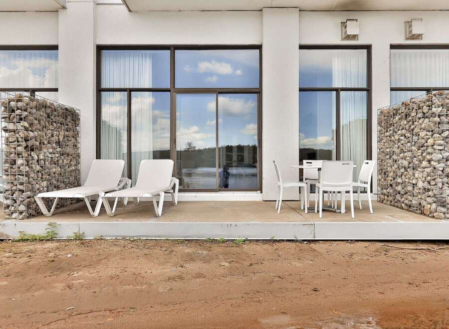 Enjoy the outdoors on this spacious patio featuring comfortable lounge chairs and a dining set, perfect for relaxation and al fresco meals.