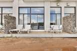 Enjoy the outdoors on this spacious patio featuring comfortable lounge chairs and a dining set, perfect for relaxation and al fresco meals.