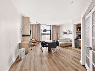 Experience modern living in this spacious studio apartment, featuring a well-appointed kitchenette with a microwave and mini-fridge.