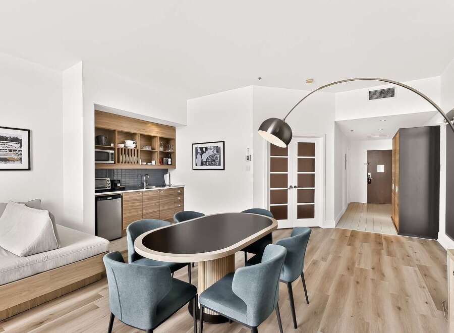 Experience modern living in this stylish studio apartment, featuring a well-equipped kitchenette with ample cabinet space and a microwave.