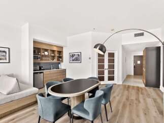Experience modern living in this stylish studio apartment, featuring a well-equipped kitchenette with ample cabinet space and a microwave.