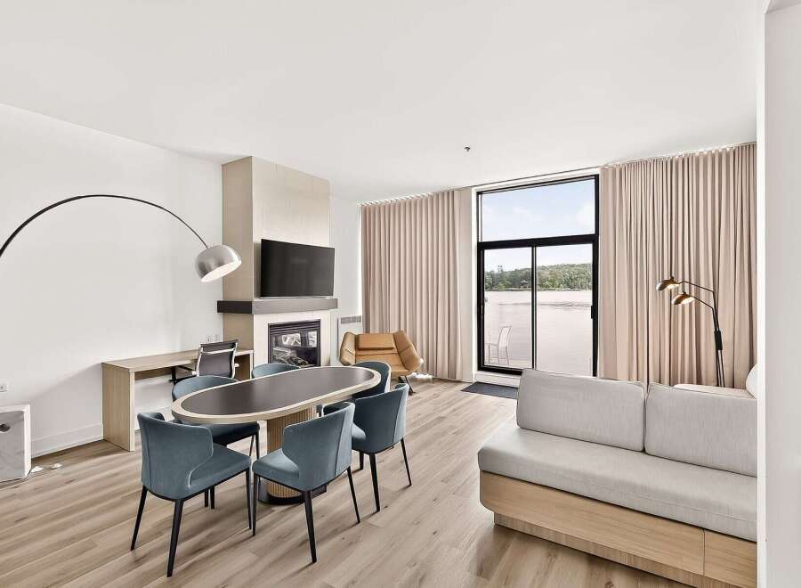 Experience modern living in this spacious suite featuring a sleek dining area with an oval table and comfortable chairs, perfect for intimate meals.
